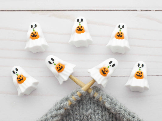 Halloween-themed ghost stitch stoppers on knitting needles