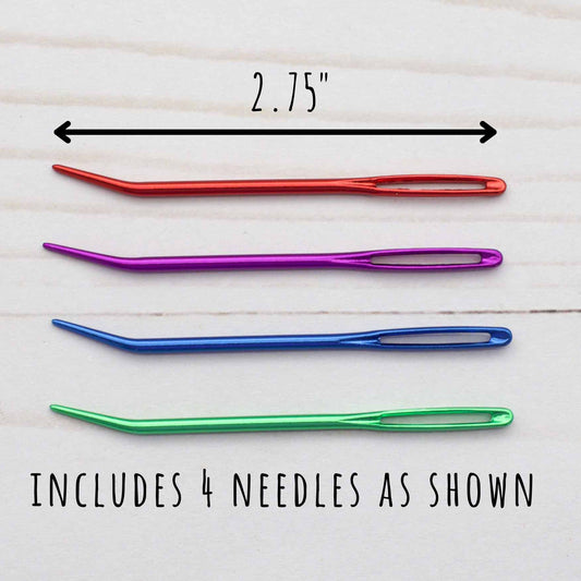 Set of four colorful needles with a measurement label on a light wooden background