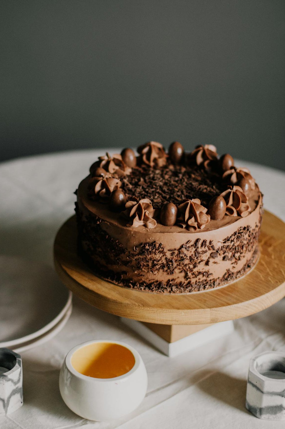Chocolate cake on a wooden stand with a neutral background