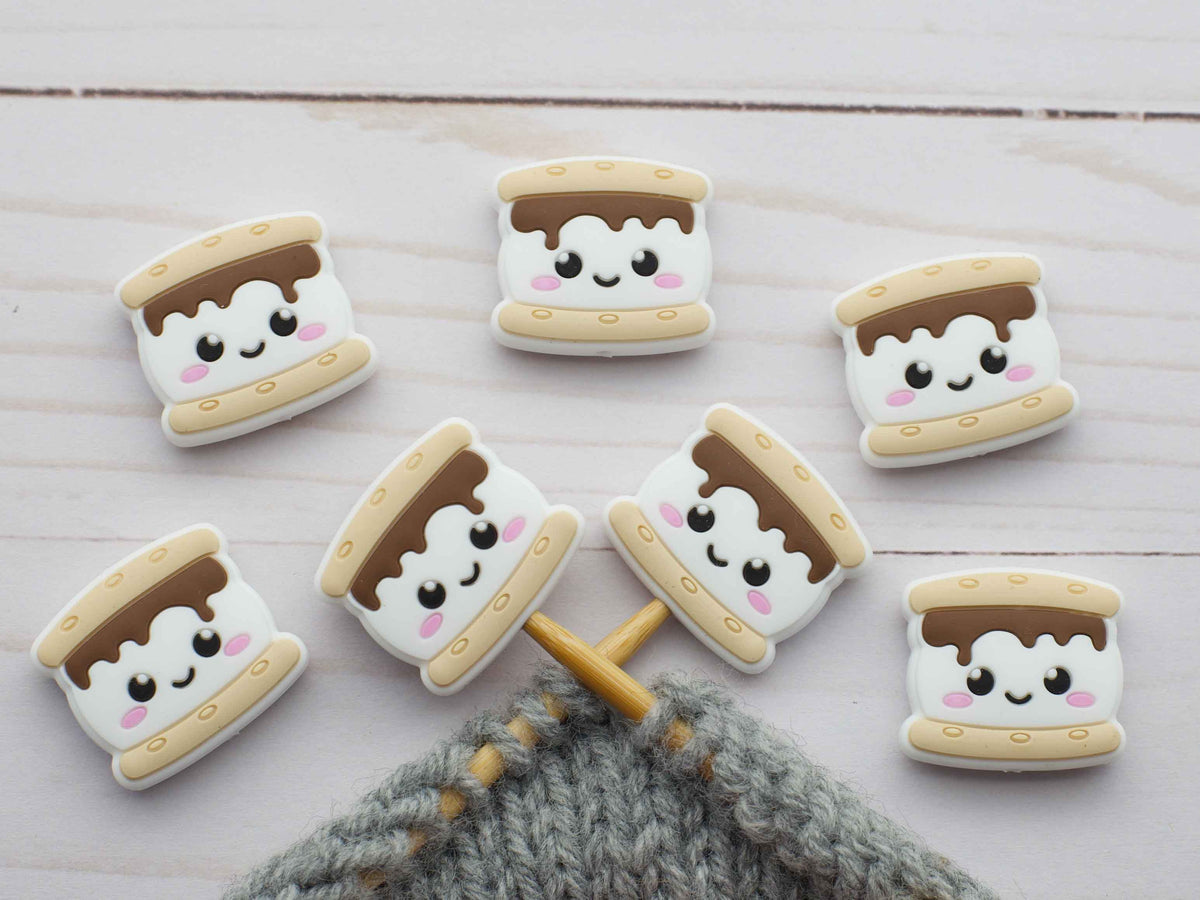 S'mores cookies stitch stoppers with cute faces on a wooden surface