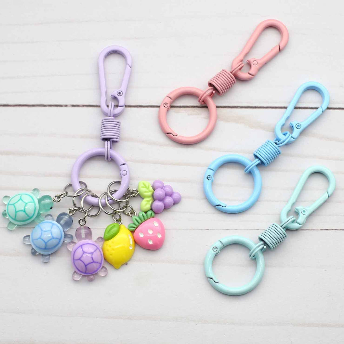 Set of colorful keychains with turtle charms on a light wooden surface