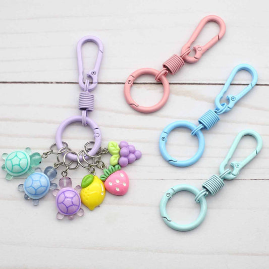 Set of colorful keychains with turtle charms on a light wooden surface