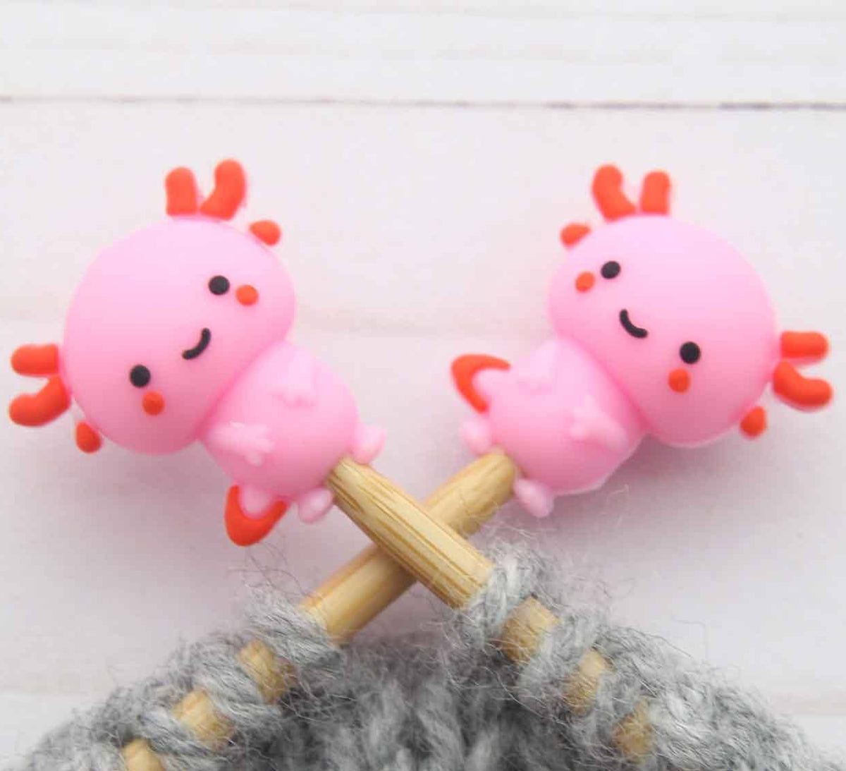 Axolotl stitch stoppers on knitting needles