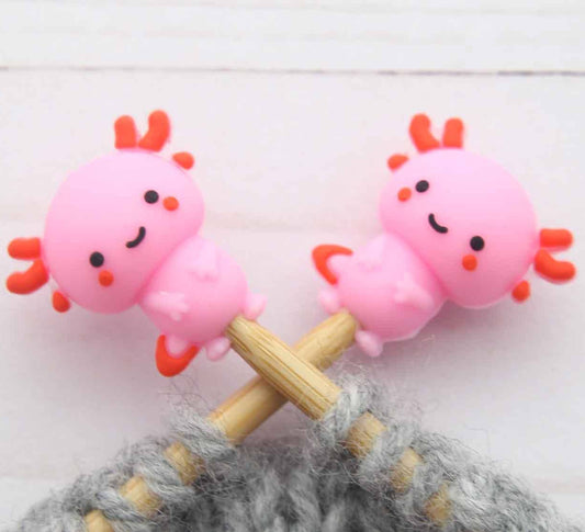 Axolotl stitch stoppers on knitting needles