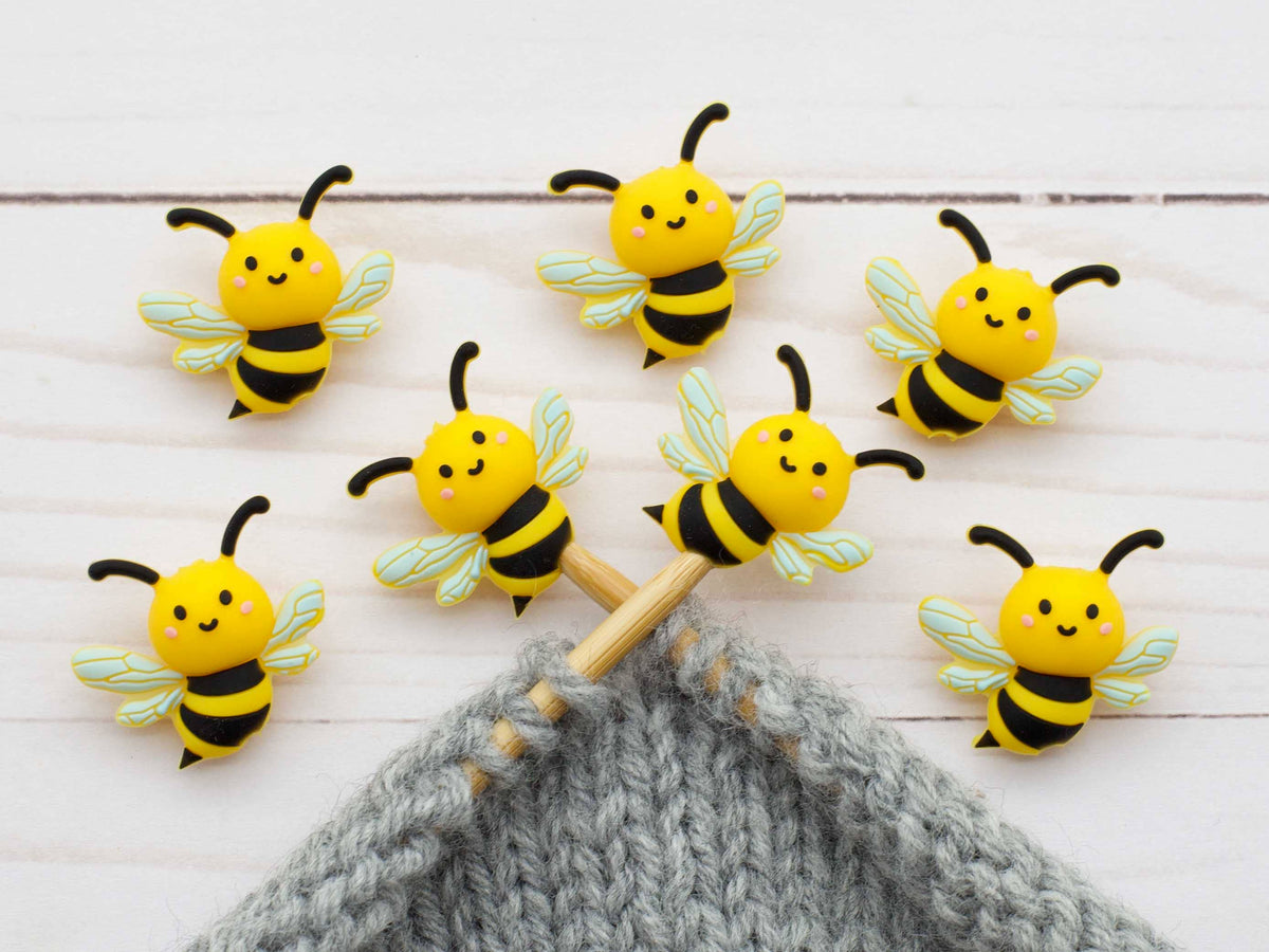 Bee stitch stoppers on knitting needles