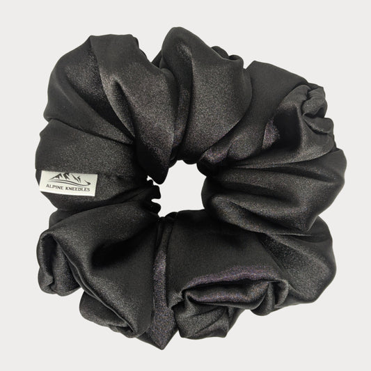 Black scrunchie with a brand label on a white background