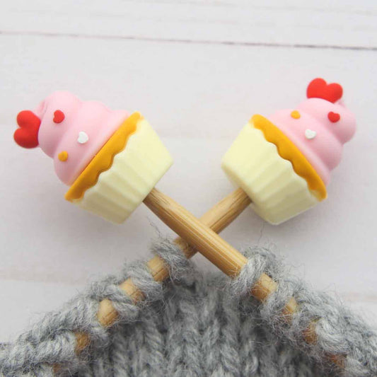 Cupcake-shaped stitch stoppers on knitting needles