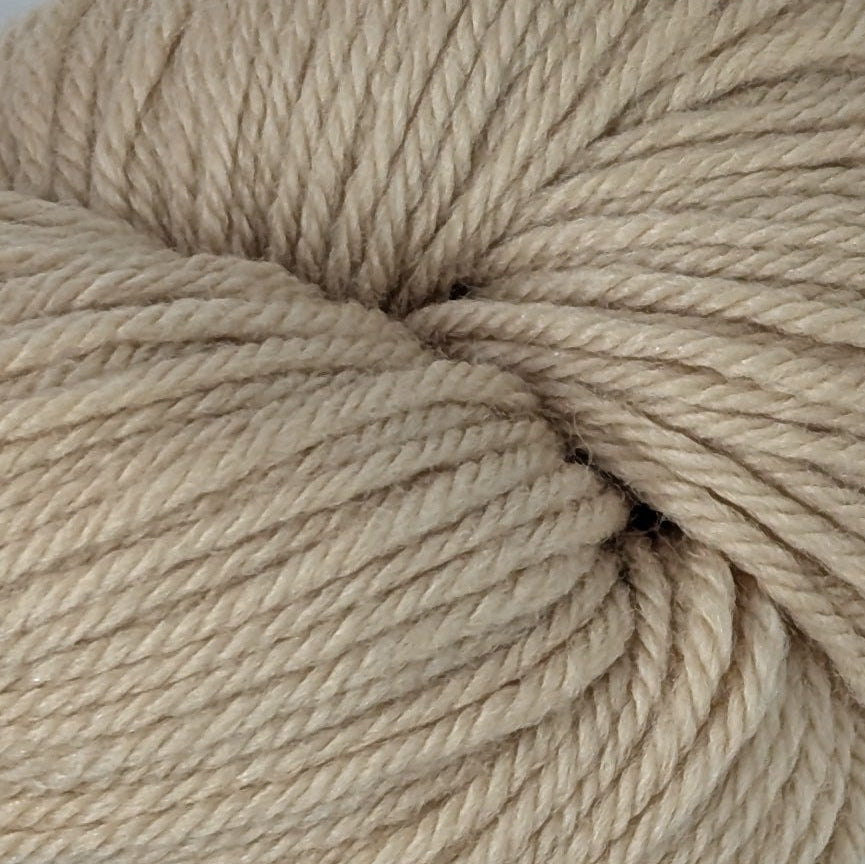 Ball of beige yarn with a label on a white background