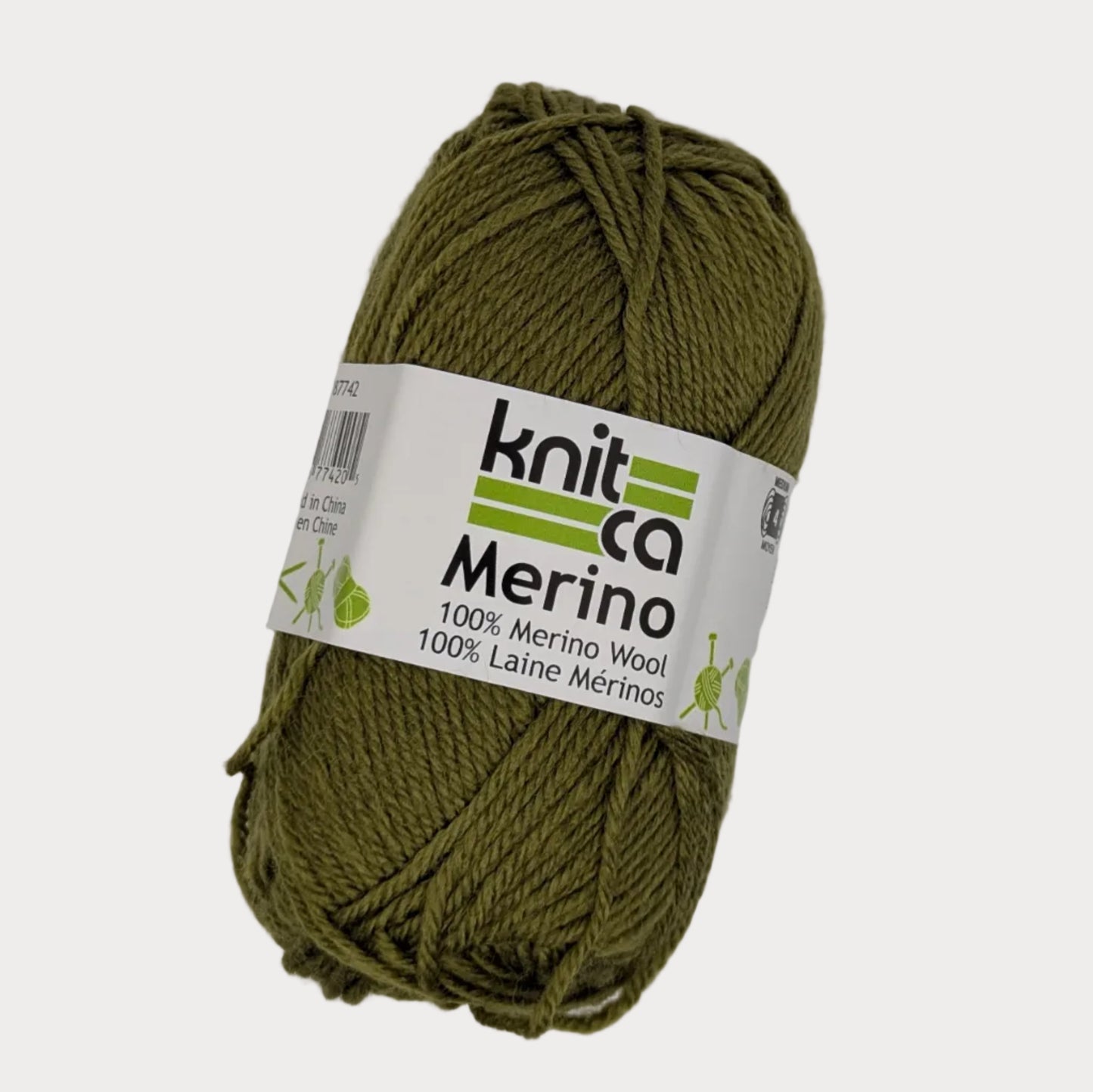 Ball of green yarn with a 'Knit Co Merino' label on a light gray background
