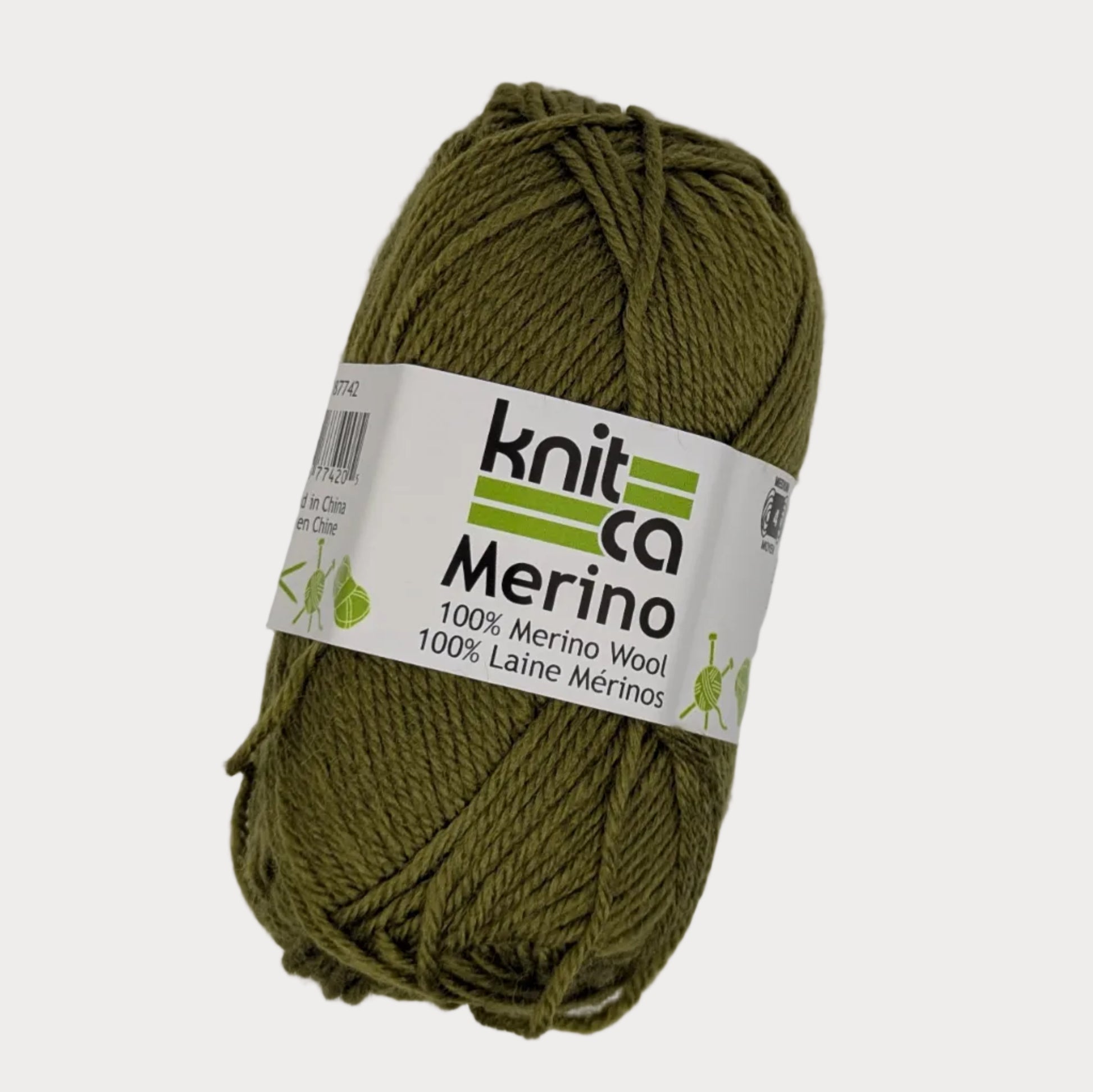 Ball of green yarn with a 'Knit Co Merino' label on a light gray background