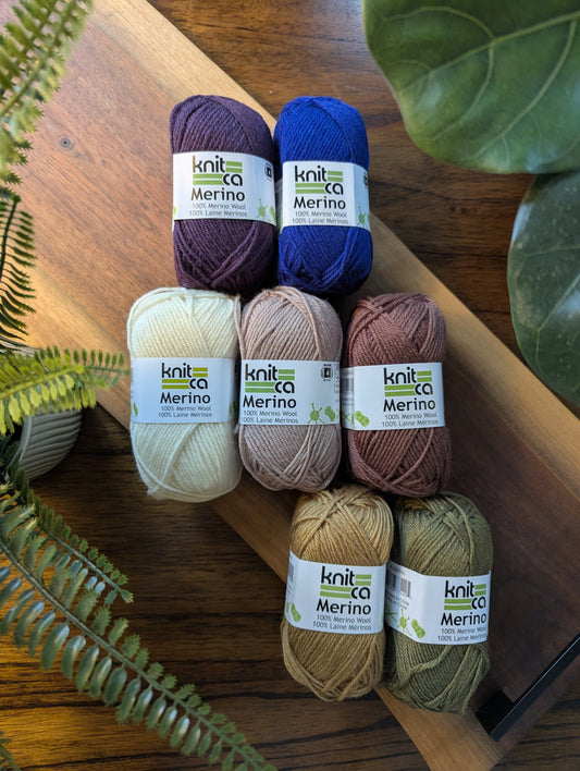 Knitca Merino yarn balls on a wooden surface with plants around