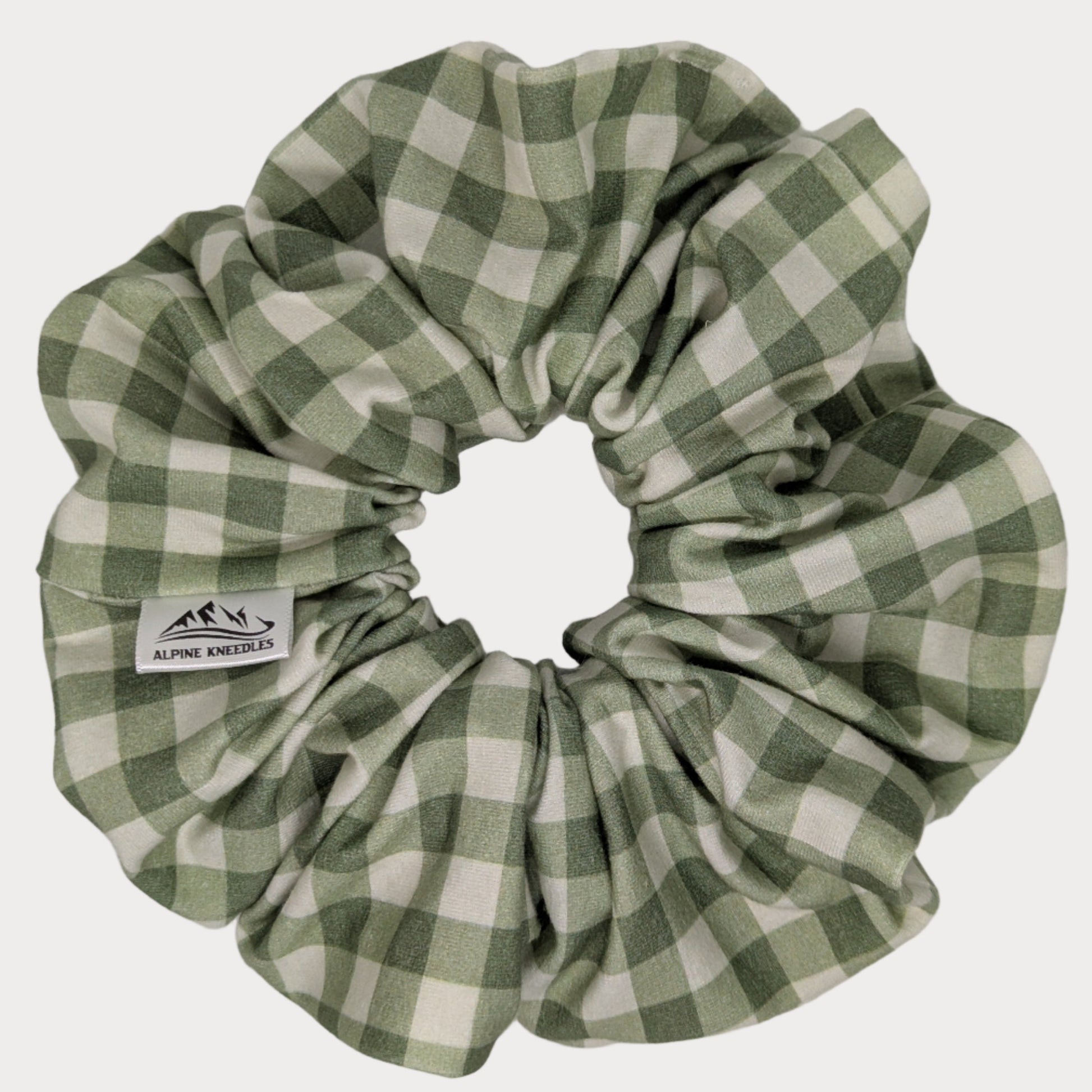 Green and white checkered scrunchie on a gray background