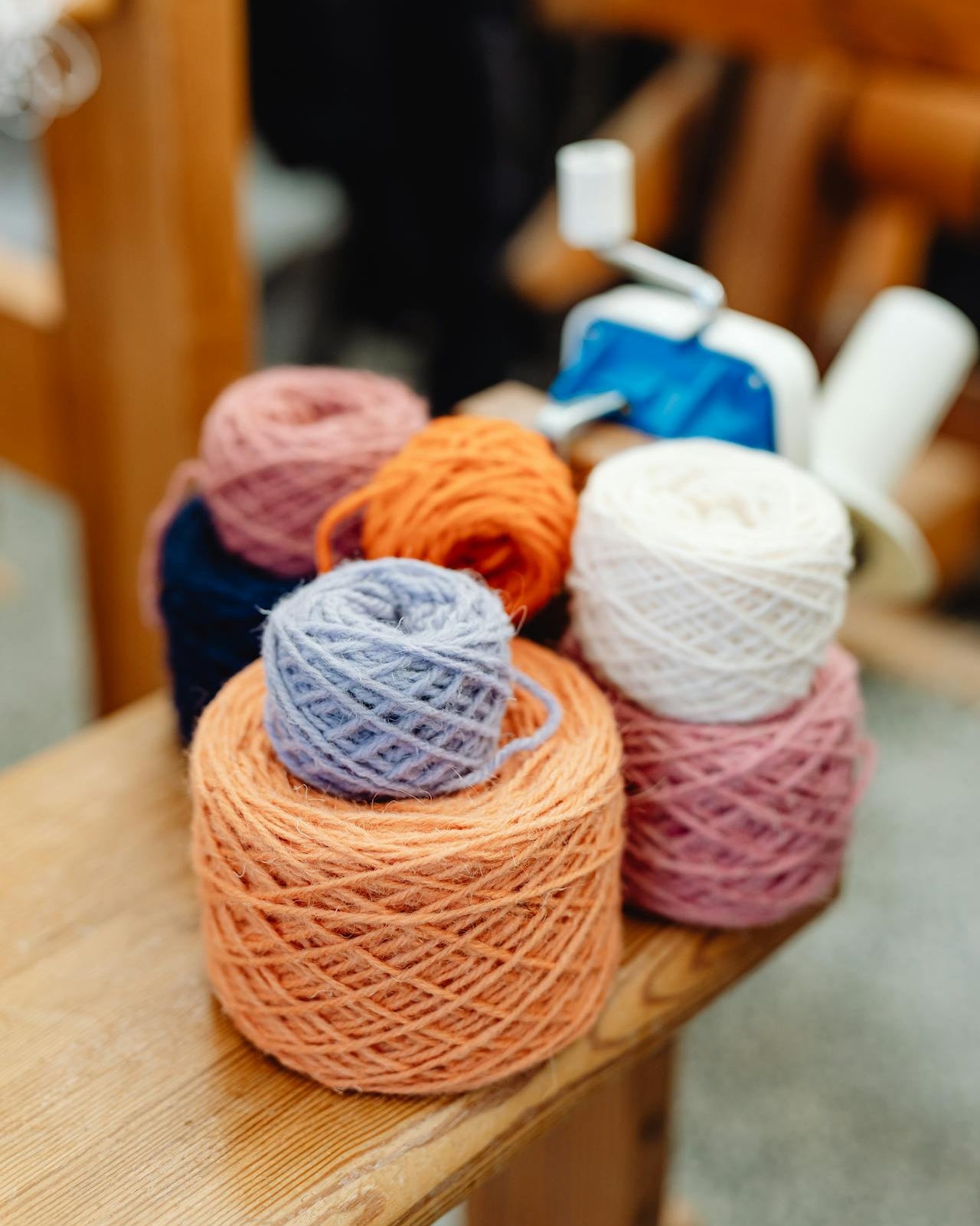 Colorful yarn balls on a wooden surface with blurred background