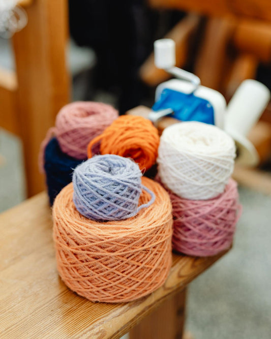 Colorful yarn balls on a wooden surface with blurred background